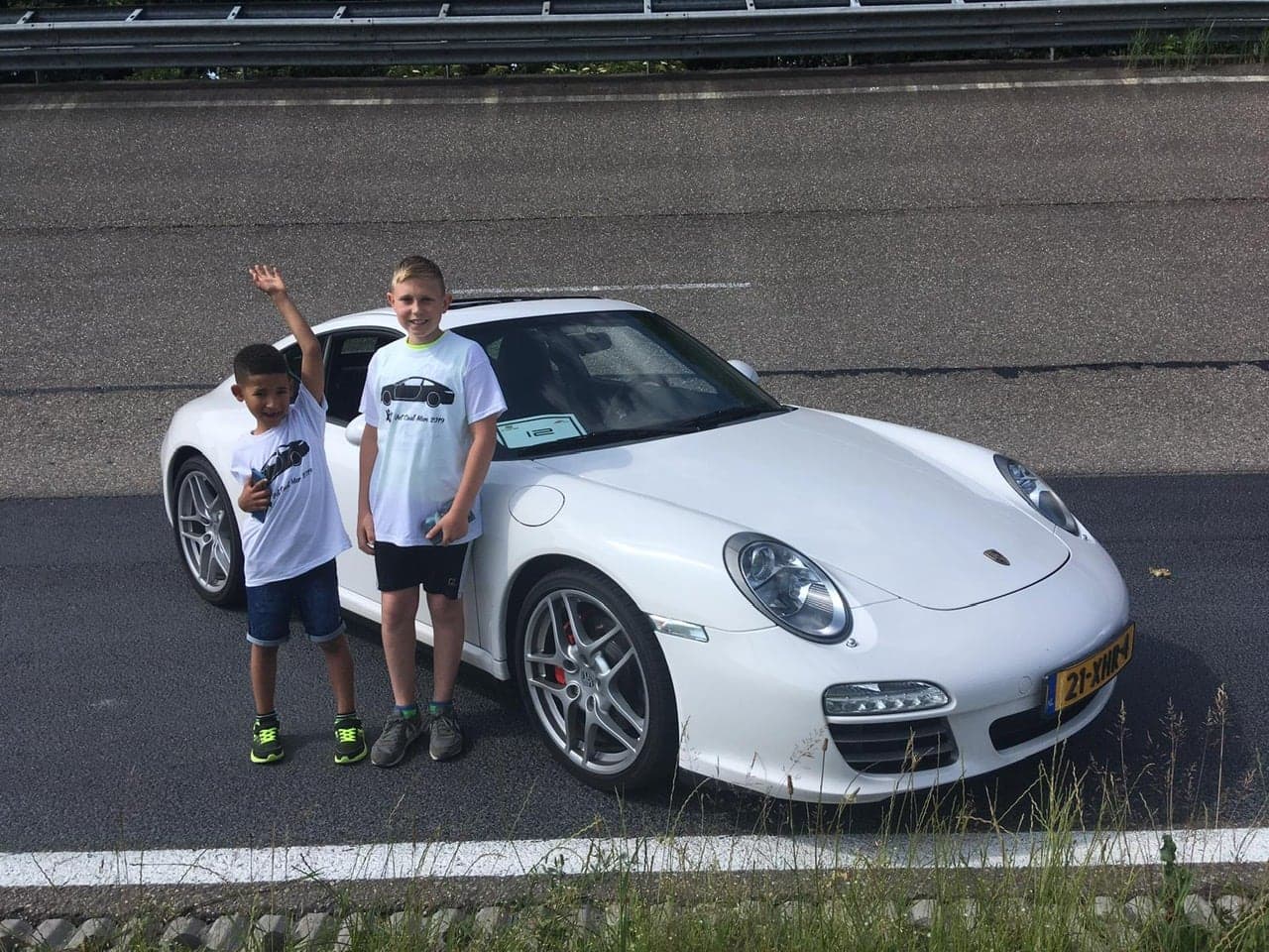 Twee jongens staand naast witte Porsche